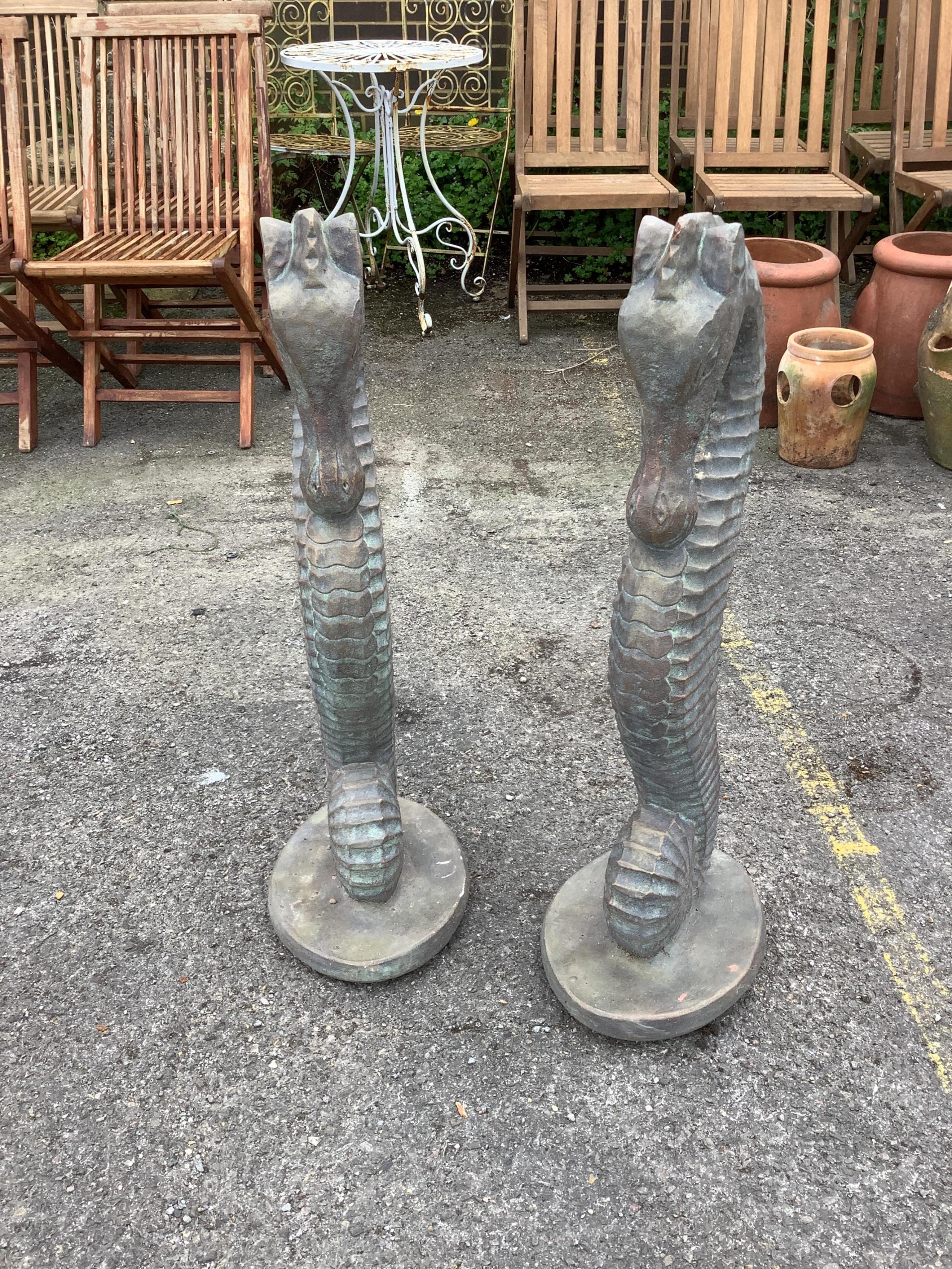 A pair of faux bronze cast stone seahorse garden ornaments, height 82cm